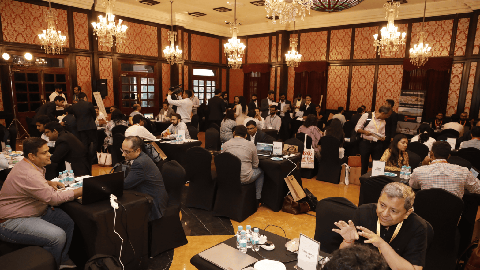 Participants at InnoWin Day engage in one-on-one sessions showcasing breakthrough Indian innovations in a busy, chandelier-lit room.