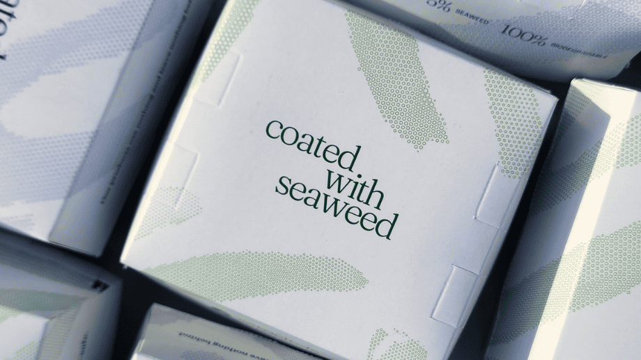 Close-up of white packaging boxes printed with the text "coated WITH seaweed".